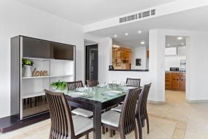 a dining room with a black table and chairs at 4 BR apartment, 8 guests in Cancún