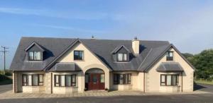 a large house with a black roof at Bree House Malin Head in Malin Head