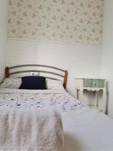 um quarto com uma cama com papel de parede floral em La Caseta de Jose em Mareny Barraquetas