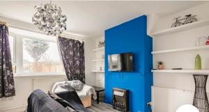 een woonkamer met een blauwe accentmuur bij Cheerful 3 bedroom entire home - newly furnished in Stockport