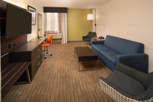 a living room with a couch and a flat screen tv at Holiday Inn Express Rochester - Greece, an IHG Hotel in Rochester