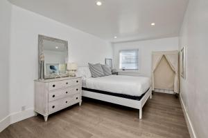 a bedroom with a bed and a dresser and a mirror at Luxury Ocean Views & Steps To The Sand - Tower 36 Lower Condo Unit in Carlsbad