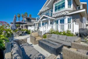 a house with a patio with a couch and chairs at Luxury Ocean Views & Steps To The Sand - Tower 36 Lower Condo Unit in Carlsbad