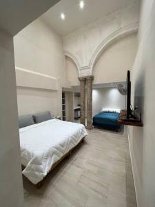 1 dormitorio con 1 cama blanca grande en una habitación en Departamento Barrio de Santiago, en Mérida