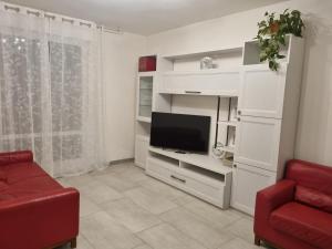 een woonkamer met een tv en een rode stoel bij Casa di Mario in Imola