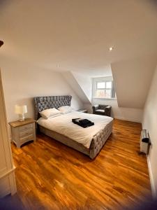 a bedroom with a bed and a wooden floor at Joe Kelly Buildings C in Withernsea
