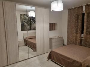 a bedroom with two beds and a mirror at Casa di Mario in Imola