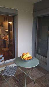 a bowl of bananas and oranges on a table at Appartement tout équipé pour 4per parking privatif in Suresnes