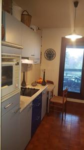 a kitchen with white cabinets and a table and a window at Appartement tout équipé pour 4per parking privatif in Suresnes