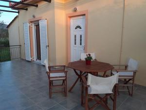 a wooden table and chairs on a patio at Phyllida Guest House - M1 in Zacharo