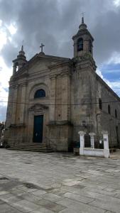 an old church with a cross on top of it at Apartamento Padrón Centro P5 by UR in Padrón