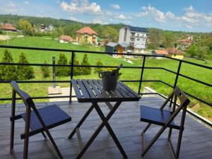 a table and two chairs on a balcony with a view at Apartman MatiNik in Mionica