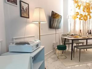 a living room with a table and a microwave on a counter at Blooming Guest House in Daegu