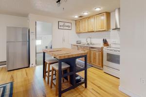 a kitchen with wooden cabinets and a wooden table at Beach Bliss in Long Beach