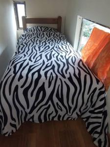 a bed with a black and white zebra blanket at La casa de chocolate 1 in Bogotá