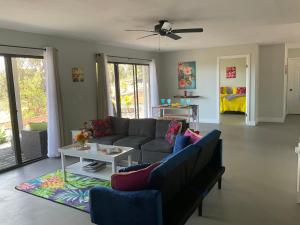 ein Wohnzimmer mit einem Sofa und einem Tisch in der Unterkunft The Art Garden- Hibiscus Guesthouse in Hawaiian Ocean View