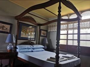a bedroom with a large canopy bed with a window at CASA CONCHITA BED & BREAKFAST in Taal