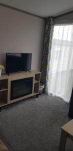 a living room with a flat screen tv on a entertainment center at Warner Lane in Selsey