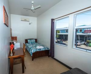 Habitación pequeña con cama y ventana en Talofa Inn, en Apia