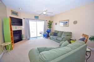 a living room with a green couch and a fireplace at Sea Bright 205 condo in Ocean City