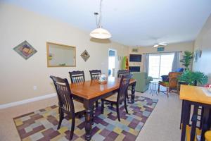 a dining room with a wooden table and chairs at Sea Bright 205 condo in Ocean City +16 photos