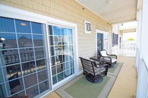 a screened porch with two chairs and windows at Sea Bright 205 condo in Ocean City