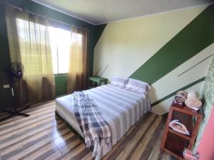 1 dormitorio con 1 cama con pared a rayas en Almendro apartments, en Fortuna