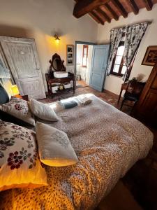 een slaapkamer met een groot bed met kussens en een piano bij Casale Saundarya - yoga e ayurveda in Toscana in Casciana Terme