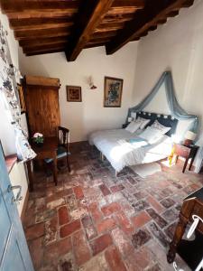 een slaapkamer met een bed en een stenen vloer bij Casale Saundarya - yoga e ayurveda in Toscana in Casciana Terme