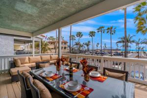 einen Balkon mit einem Tisch und Stühlen sowie Meerblick in der Unterkunft Balboa Beauty in Newport Beach