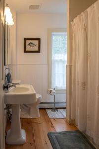 baño con lavabo y aseo y ventana en Parker Head House Popham Beach Phippsburg, en Phippsburg