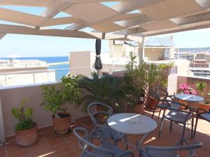 un patio con mesas y sillas y vistas al océano en Pension Eva en La Canea