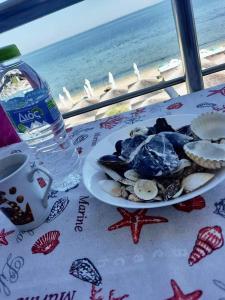 un piatto di cibo su un tavolo con vista sulla spiaggia di Aktis Sea View Studios a Perea