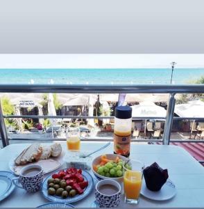 un tavolo con piatti di cibo e una vista sulla spiaggia di Aktis Sea View Studios a Perea