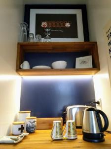 a counter with a tea kettle and cups on it at A little bit of country on the city's doorstep in Napier