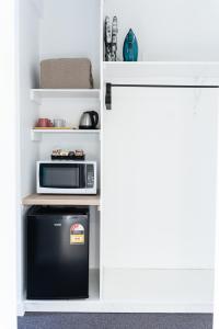 a small kitchen with a microwave and a refrigerator at Gosford Palms Motor Inn in Gosford