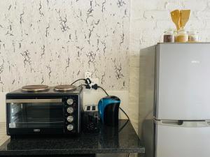un forno a microonde seduto su un bancone accanto a un frigorifero di Views from The 509 a Johannesburg