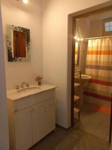 a bathroom with a sink and a bathroom with a flag at Amplia casa para 6 huéspedes en Mendoza in Godoy Cruz