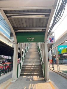 een trap naar een brug met een bord erop bij 1bedroom condo near BTS Onnut station in Amphoe Phra Khanong