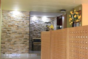 Habitación con pared de piedra y tabique de madera. en Hotel Ajka 1, en Ajka