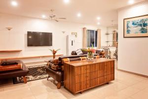 a living room with leather furniture and a flat screen tv at Marlin House in Nadi