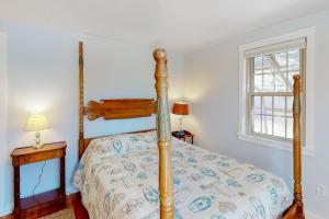 a bedroom with a bed with a wooden post at Adventures on Buzzards Bay in Bourne