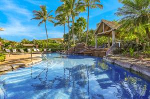 una piscina en un complejo con palmeras en Nihilani 31A, en Princeville