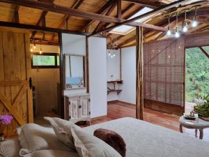 1 dormitorio con 1 cama en una habitación con techos de madera en MoiraEcolodge, en Córdoba