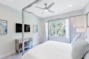 a bedroom with a bed with a ceiling fan and a window at The Blue Coral in Naples