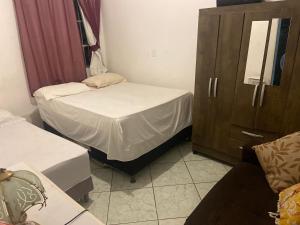Habitación pequeña con 2 camas y armario en Espaço Verde en Vitória