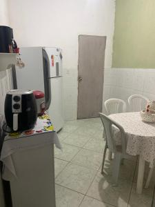 een keuken met een tafel en een koelkast bij Espaço Verde in Vitória