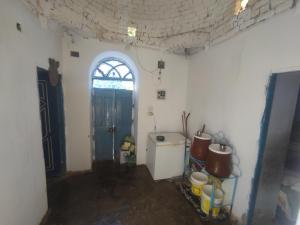 a room with a kitchen with a door and a window at البيت النوبي in Naj‘ al Maḩaţţah