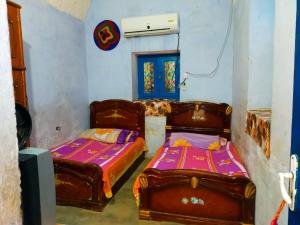 two beds in a room with two beds sidx sidx sidx at البيت النوبي in Naj‘ al Maḩaţţah