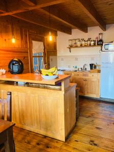 una cocina con armarios de madera y un bol de plátanos en Horizonte Chapelco en San Martín de los Andes